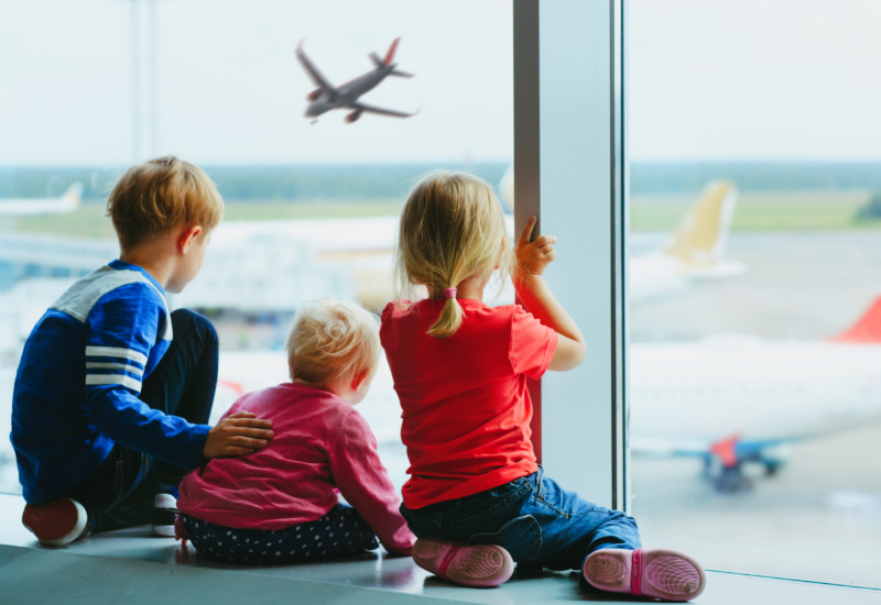 Best family travel insurance- young children waiting at the airport