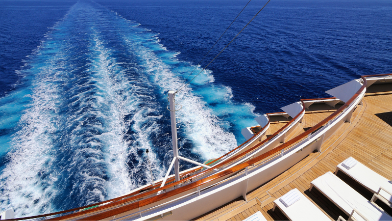 Best cruise travel insurance- looking off the stern of a cruise ship over the ocean