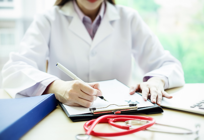 Medical professional working on a patient's chart for travel medical insurance