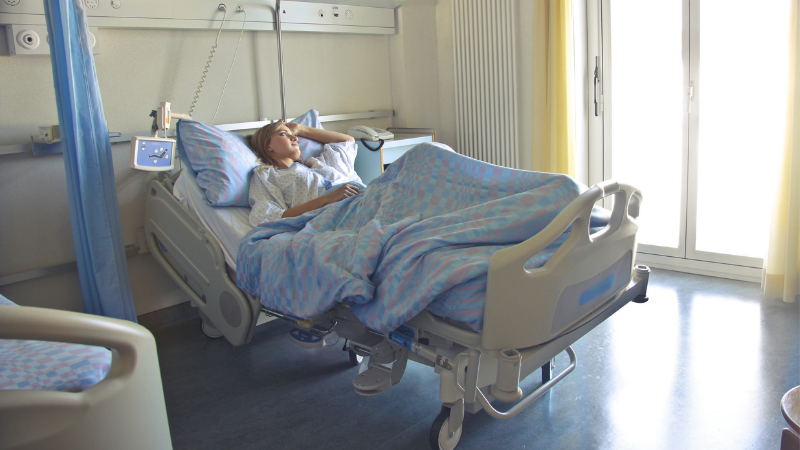 Travel insurance covers medical emergencies abroad- woman in hospital bed
